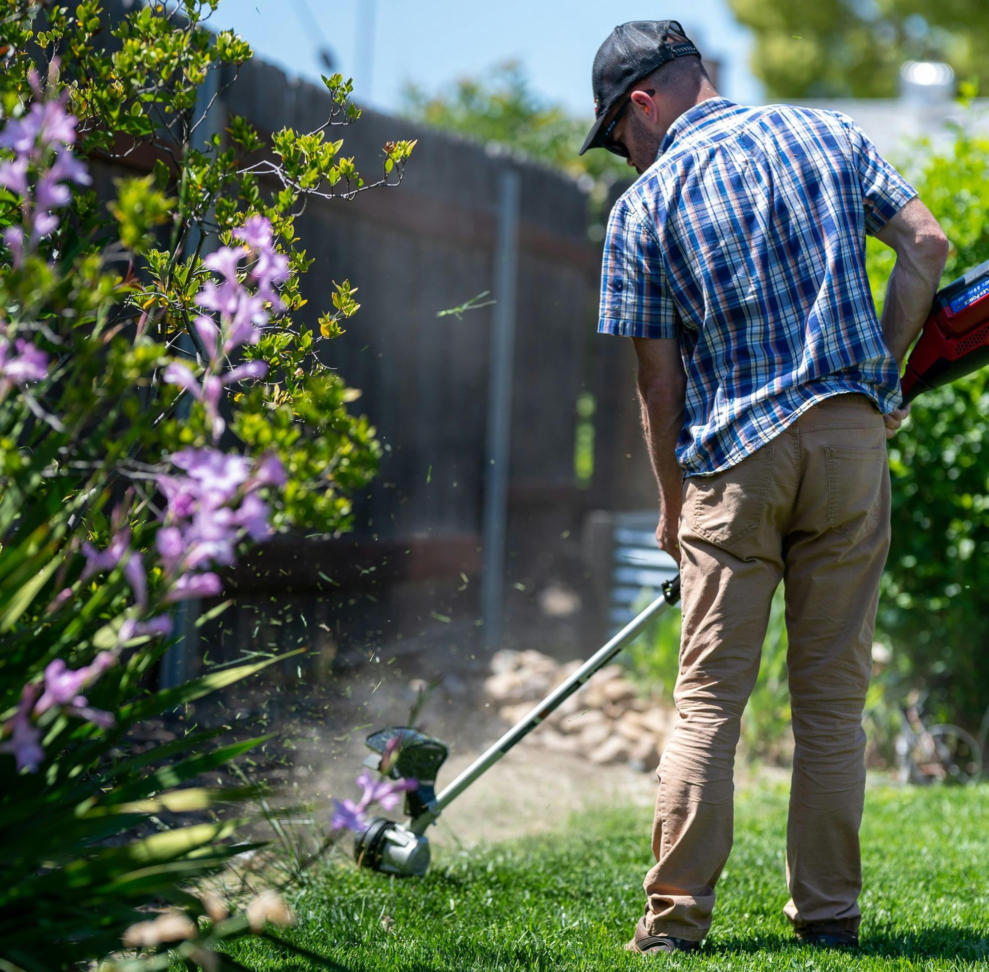 male weed eating grass